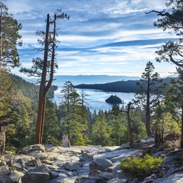 Image capured a brisk fall morning at Emerald Bay, Lake Tahoe. A few whispy morning clouds coveing the sky with the sun rising on the left side of the image.