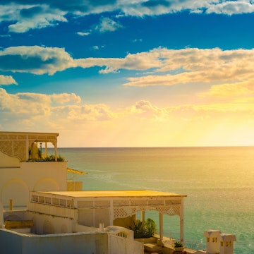 Hammamet, Tunisia. Image of architecture of old medina with dramatic sky at sunset time.; Shutterstock ID 731409280; Your name (First / Last): Lauren Keith; GL account no.: 65050; Netsuite department name: Online Editorial; Full Product or Project name including edition: Tunisia Destination Page image update