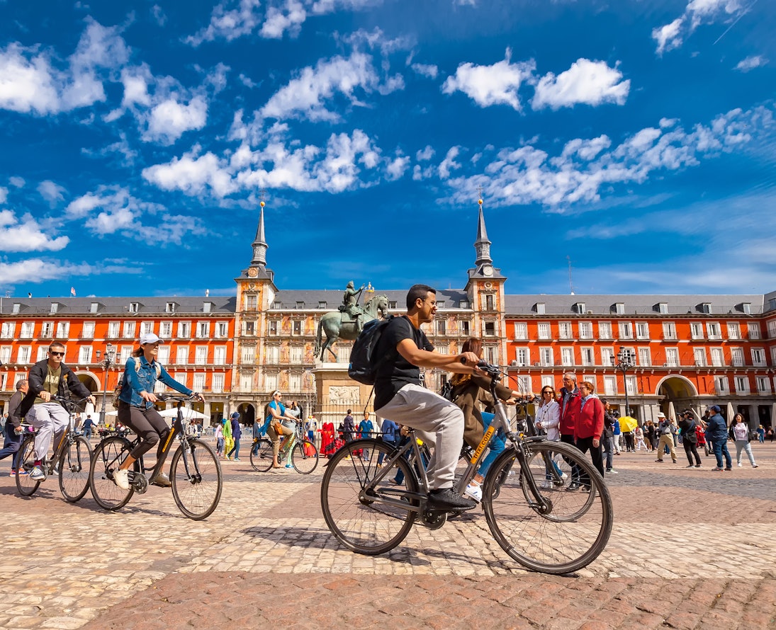 Spain, Madrid..A view of La Plaza Mayor square in Madrid where there were a group of tourists riding bicycles. The Plaza Mayor square is one of the most famous squares in the town and located in the city center. People walk and cycle through the streets.The Plaza Mayor (Main Square) was built during Philip III's reign (1598–1621).