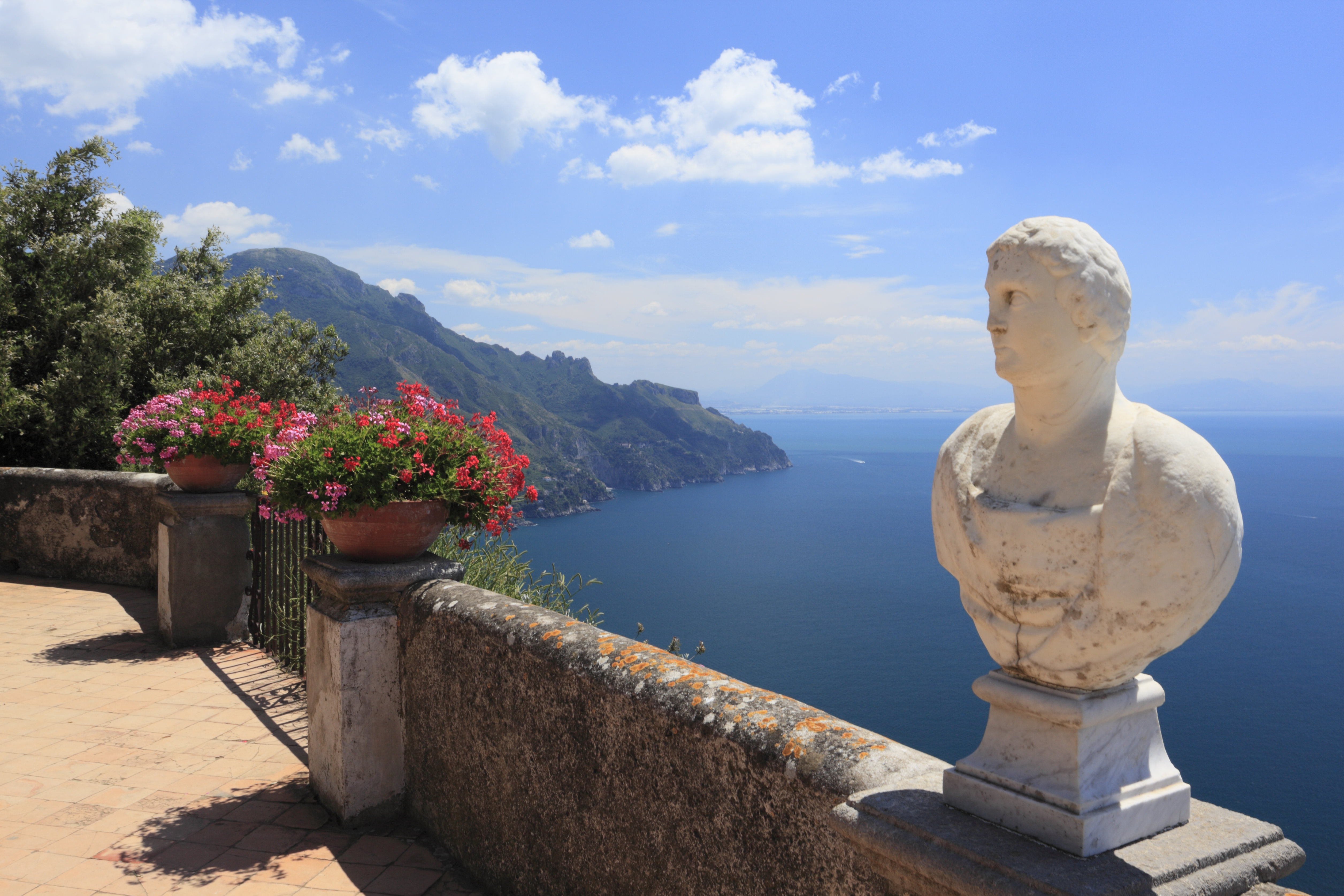 A stone bust and flowers on the coastal terrace of Villa Cimbrone.