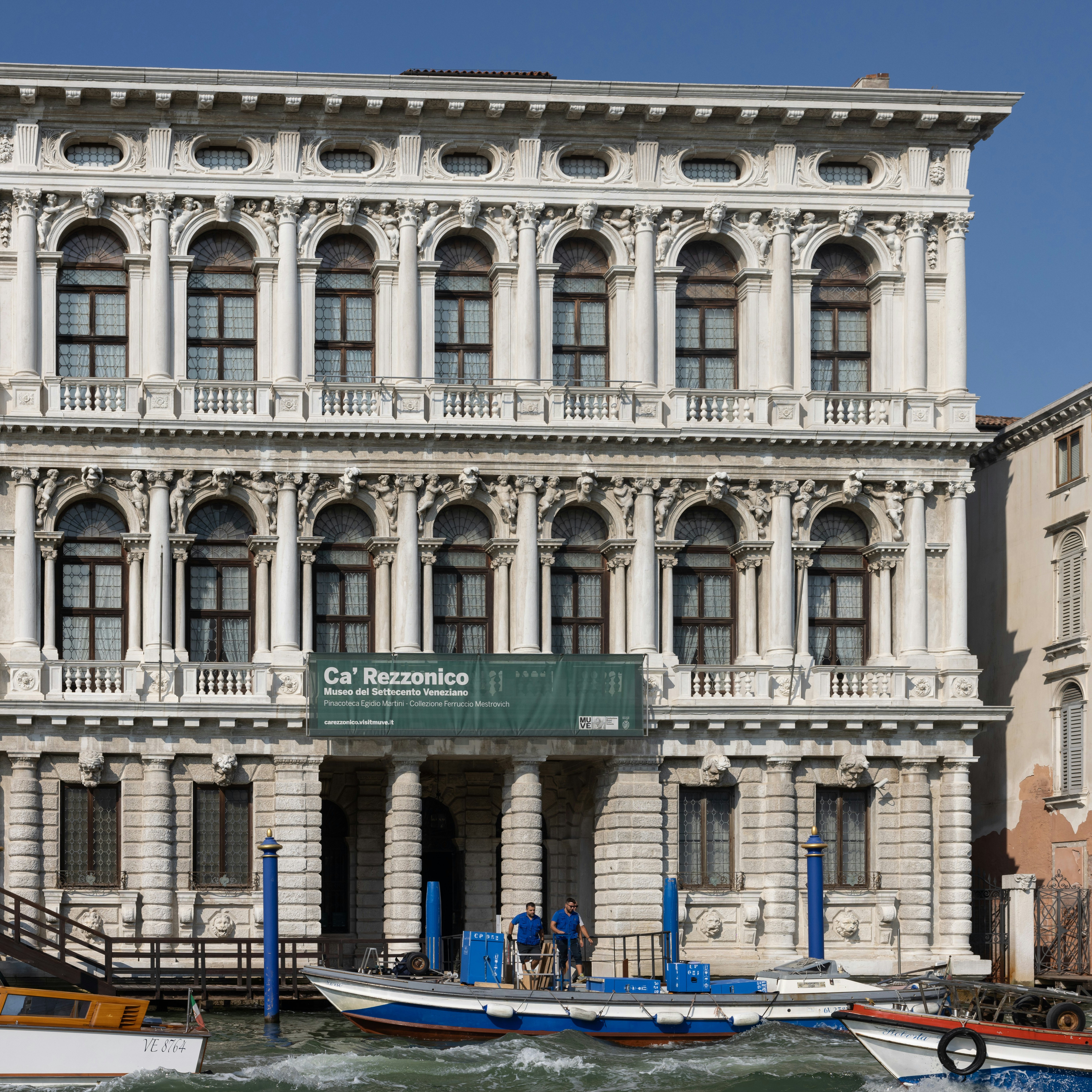 The white marble facade of Ca' Rezzonico on the Grand Canal in Venice. Italy