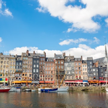 Honfleur downtown in Normandy France
526919853
Travel, Normandy, People Traveling, Tourism, Building Exterior, Cloudscape, Le Havre, Sail, Medieval, History, Journey, Exploration, Ancient, French Culture, Famous Place, Construction Industry, Architecture, Nature, Urban Scene, Outdoors, Honfleur, France, Europe, Summer, Bay Of Water, Cloud - Sky, Sea, River, Water, House, Church, Built Structure, Commercial Dock, Harbor, Cityscape, City, Village, Town, Nautical Vessel